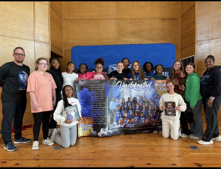 The Ruth Doyle girls basketball team receive banner for undefeated (14-0) season.