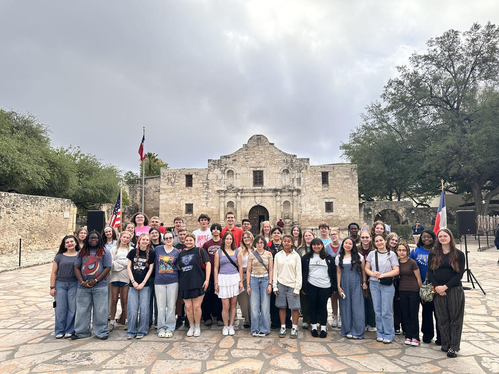Orchestra students posing in front of The Alamo