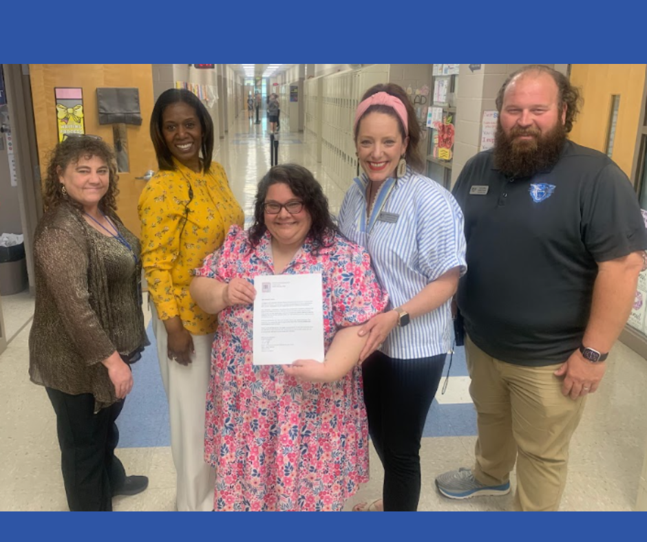 Mrs. Castles holding her award surrounded by Simon Administration