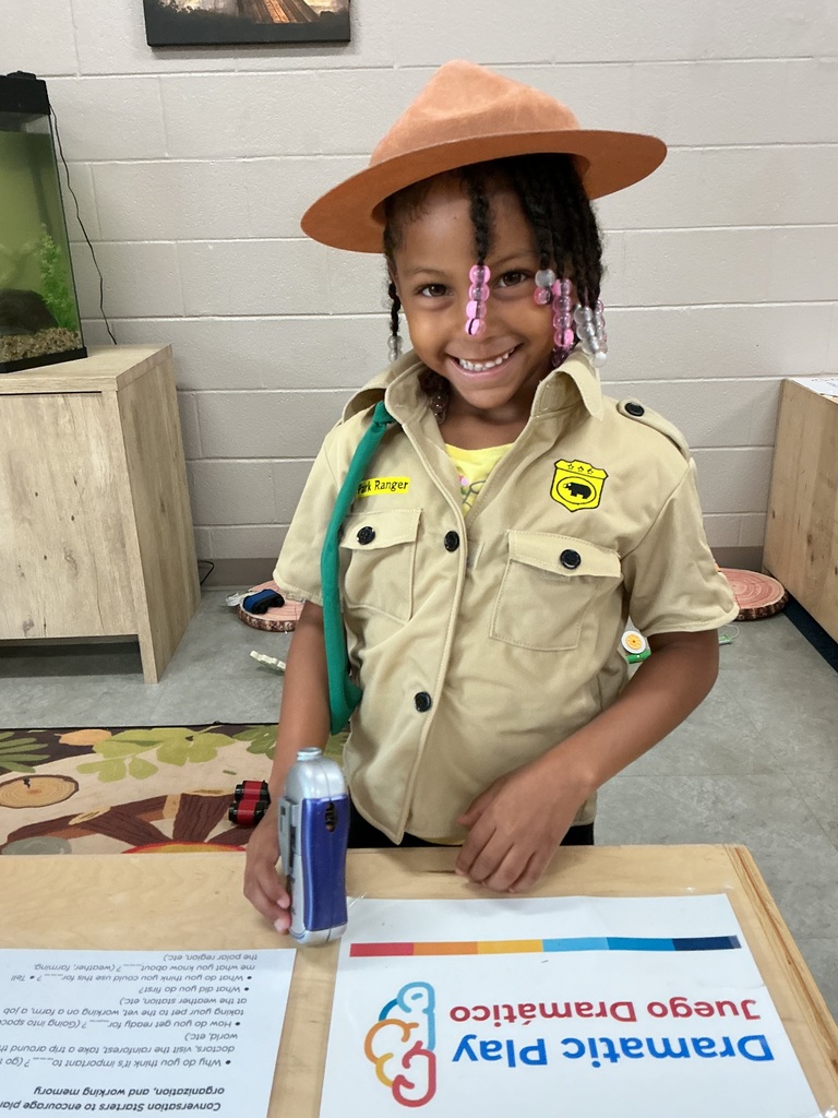 child pretending to camp wearing camping gear and using a canteen 