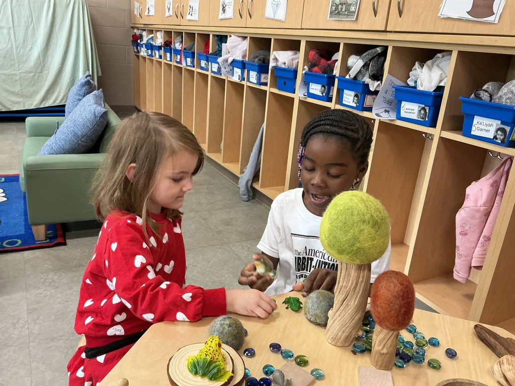 children playing with toy trees and frogs 