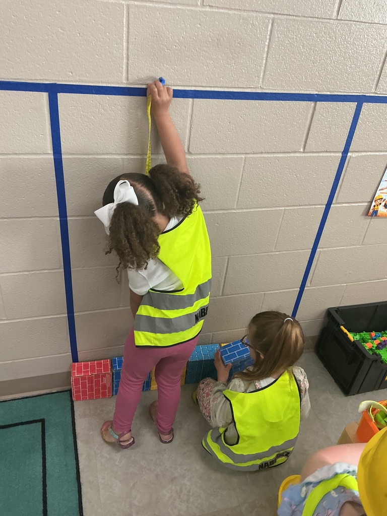 child measuring how tall to build their house 