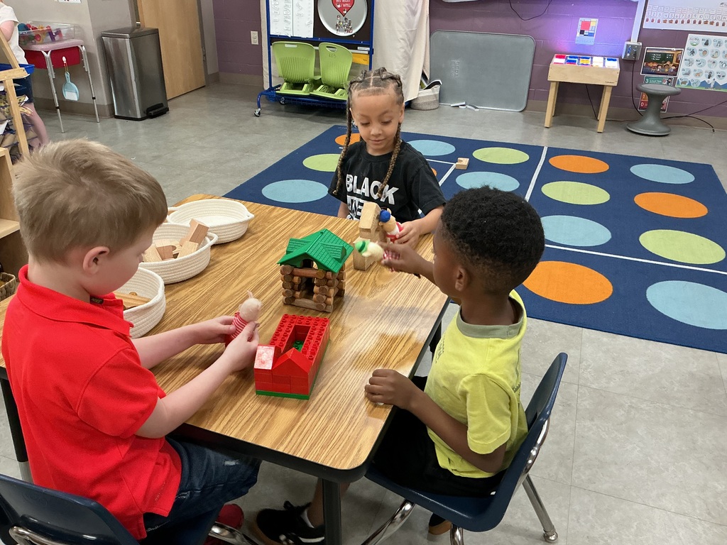 boys building homes for three little pigs