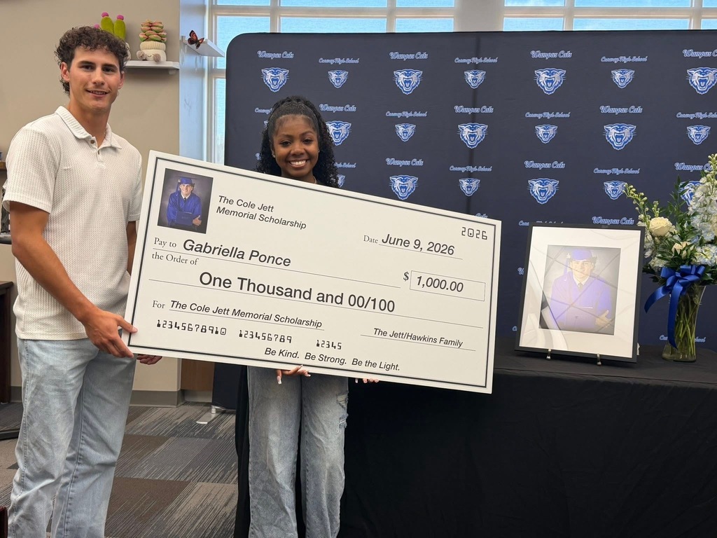 Scholarship recipient holding a large check.