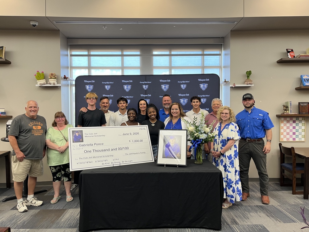 Scholarship Recipient surrounded by family members of Cole Jett, recipient family members and school staff.  