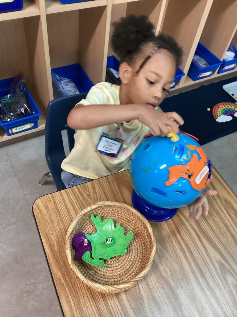 child matching the different continents on the globe using matching skills