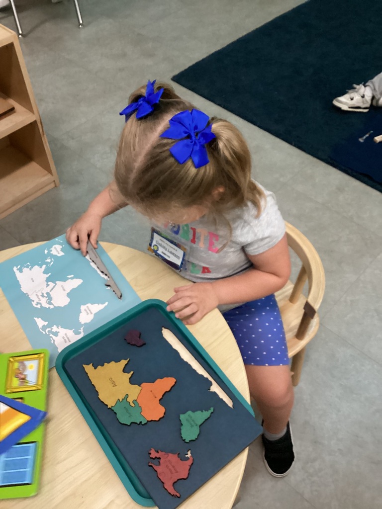 child using matching skills to identify and place the correct continents on the visual map