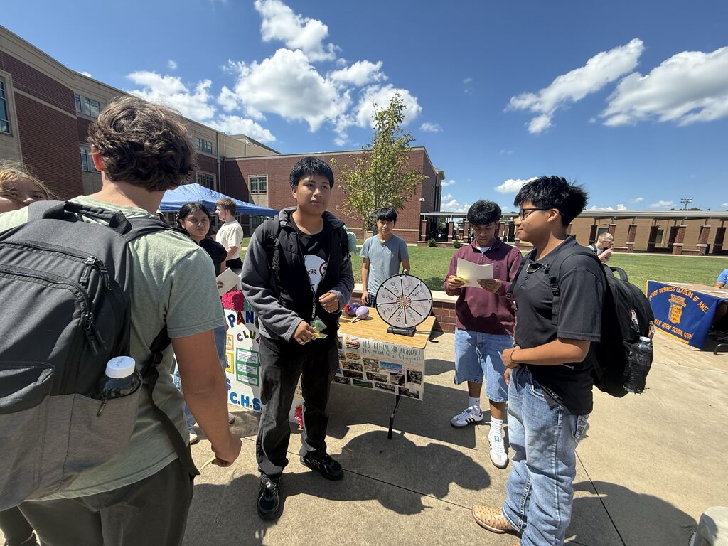 Spanish club member speaking with fellow students.