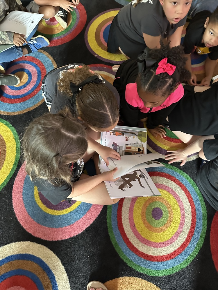 kids reading a book. 