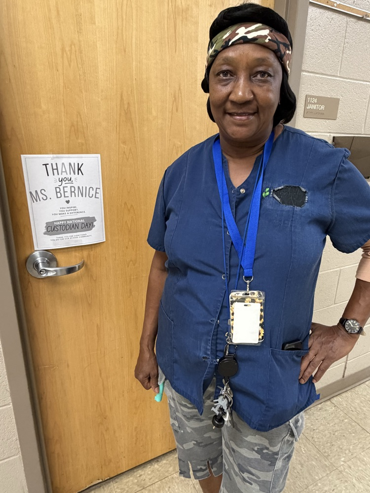 Ms.Bernice standing next to a sign that says Thank You!