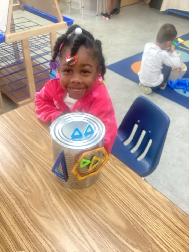 child used different shaped	 magnets on to an aluminum can