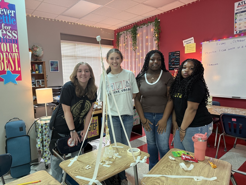 students posing with their completed structure