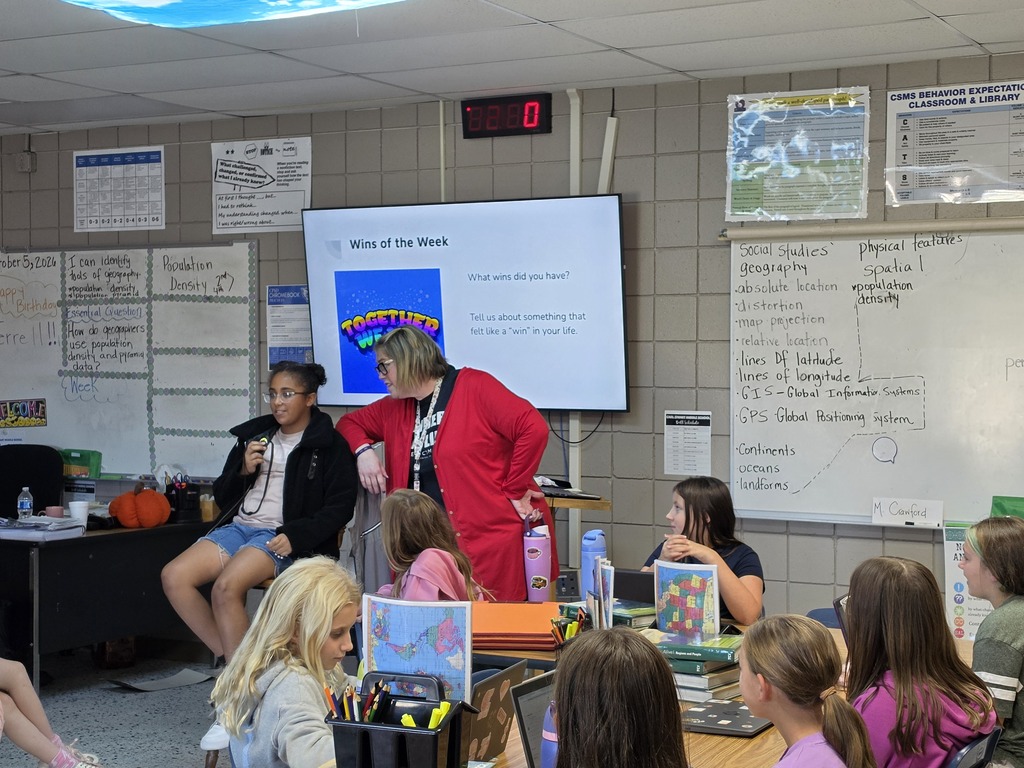 Mrs. Williams talking with a student at the front of the classroom