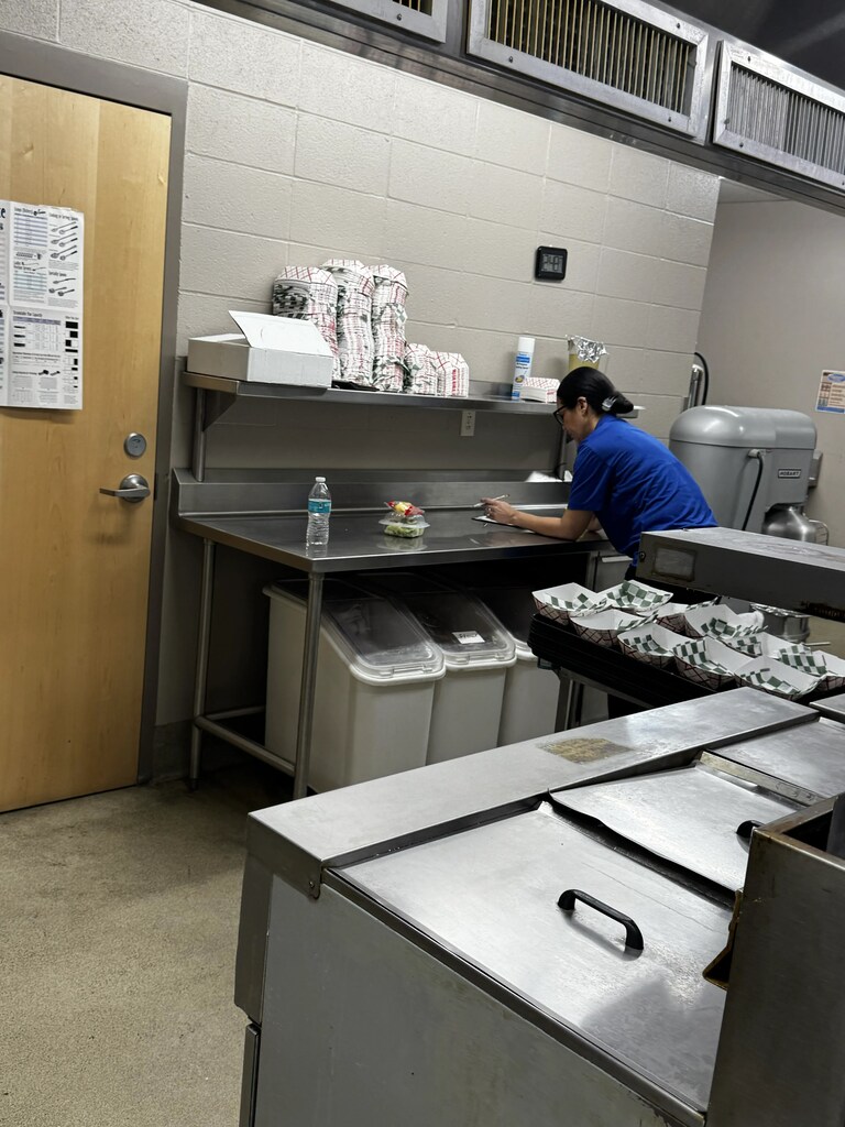 Food Service Worker leaned over counter worker