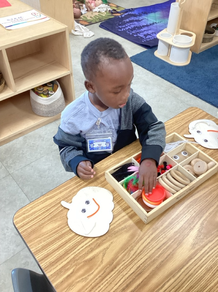 child using loose parts to create emotion face on pumpkin