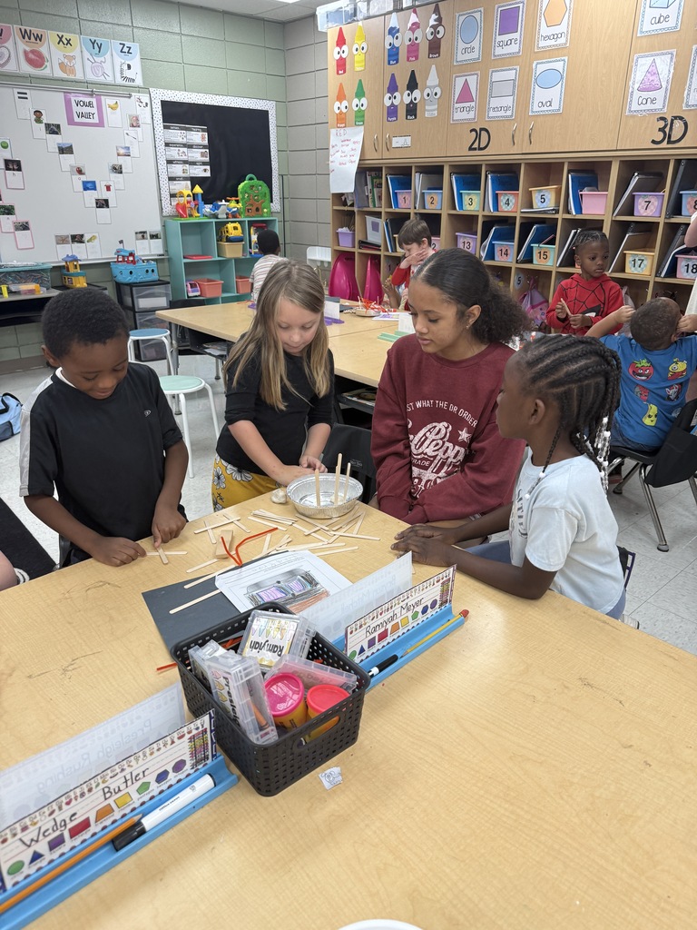middle school student working with 3 elementary students