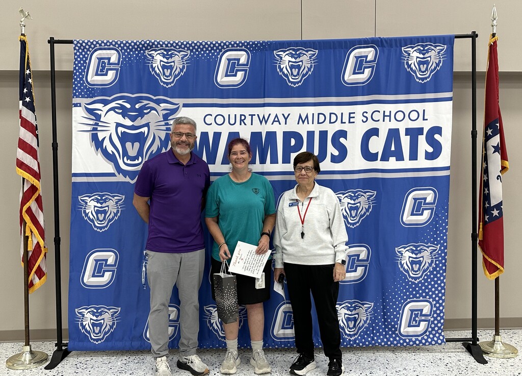 September Employee of the Month - Crystal Hansen stands in front of our CMS Wampus Cat backdrop with Mr. Etters and Mrs. Goodnight