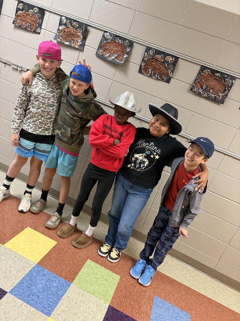 Five young people stand together in a hallway. Four wear hats; three wear sneakers. Colorful carpet covers the floor.
