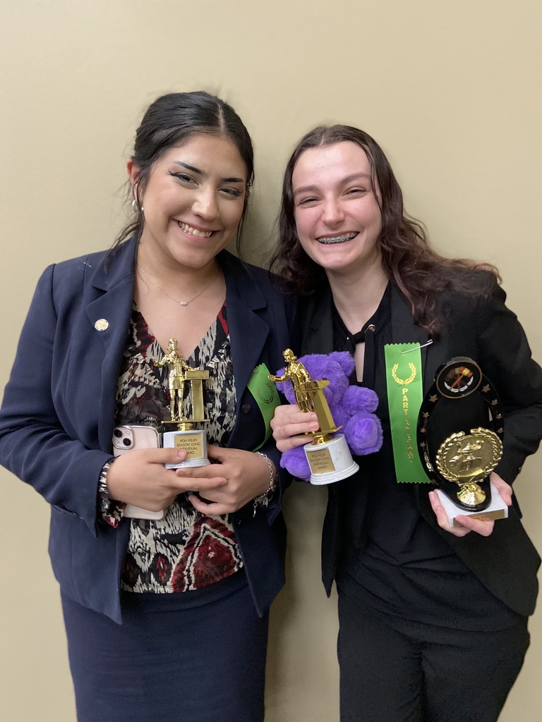 Image of two students posing with awards.