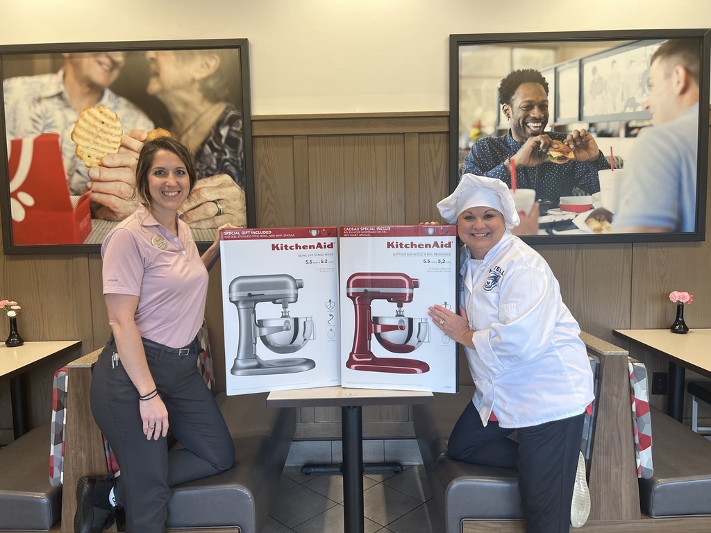 Image of two adults posing with donated stand mixers.