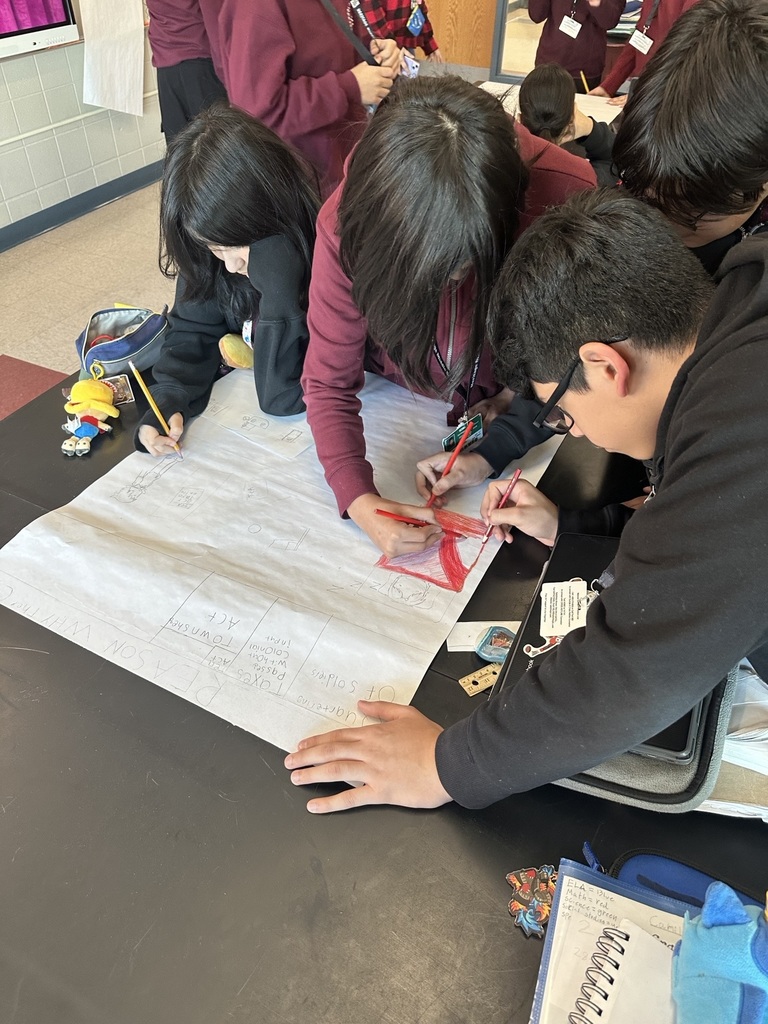 three boys writing down words on paper