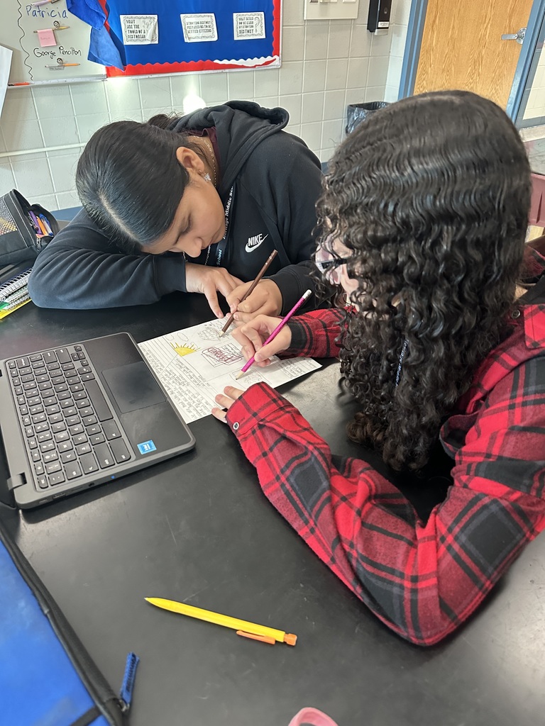 two girls writing down words on paper