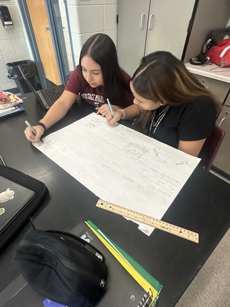 two girls writing down words on paper