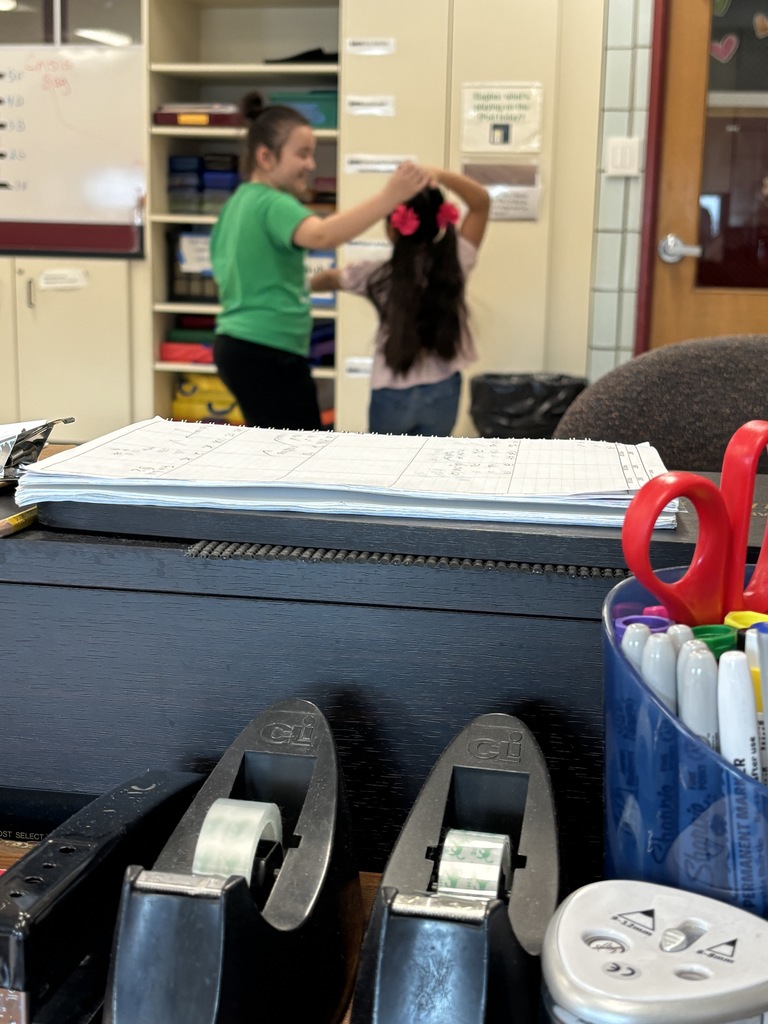 two girls dancing in a classroom