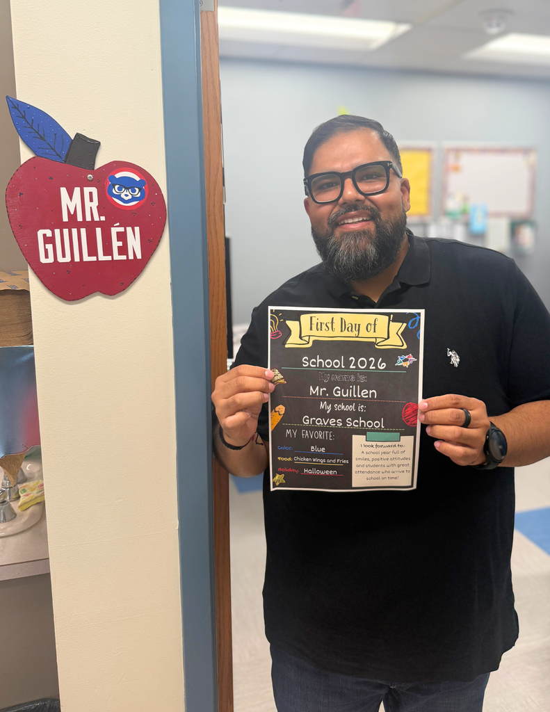 A man holding a certificate near a sign that says "Mr. Guillén." The certificate mentions "School 2026" and lists "Mr. Guillén" as a teacher at "Graves School."
