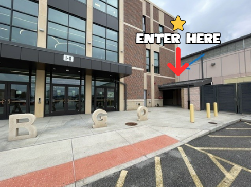 School building exterior with glass doors labeled I-8 and a side entrance marked by a red arrow and “ENTER HERE” graphic.