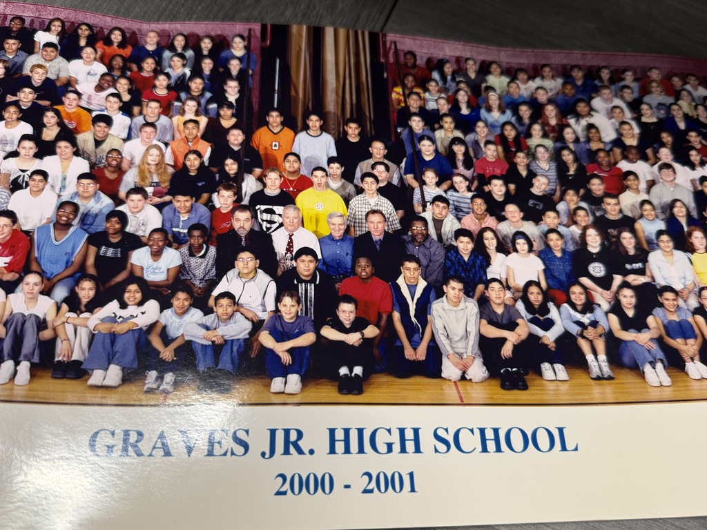 A large, diverse group of students and staff pose in rows for a Graves Jr. High School photo, 2000–2001; the scene feels warm and celebratory.