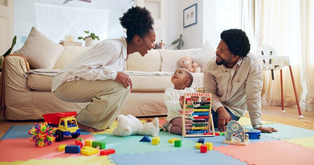 Parents and child playing and engaging on floor from First Five Years fund website