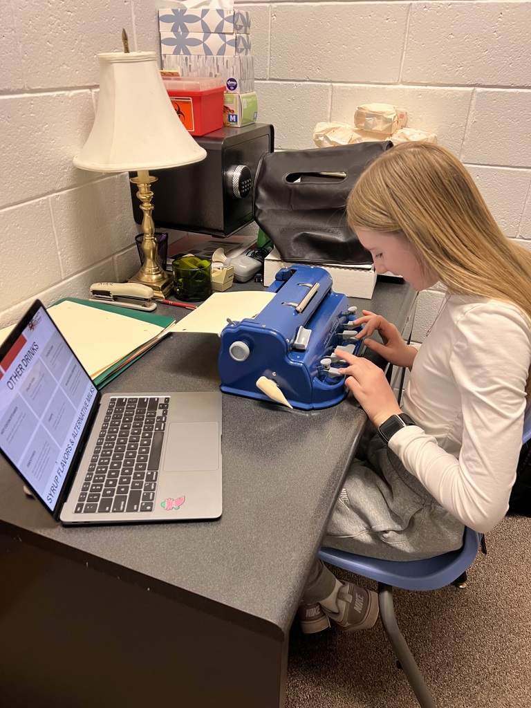 student typing on braille machine