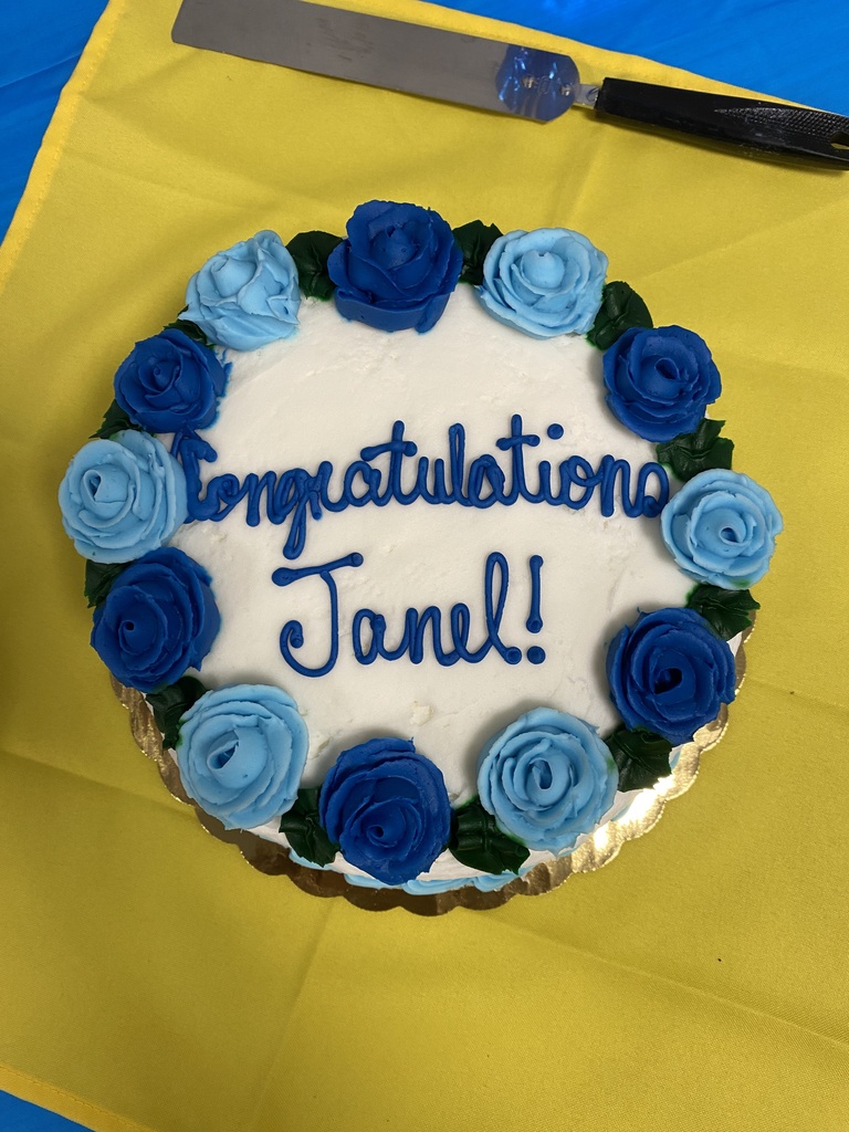 White round cake with Congratulations Janel and blue flowers