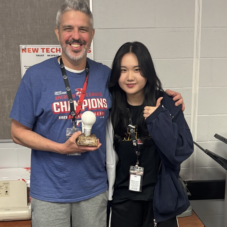 two teachers holding an award.