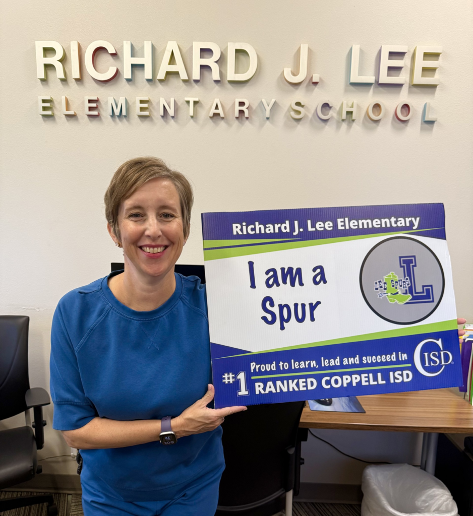 image of campus secretary holding blue and green yard sign that says I am a Spur