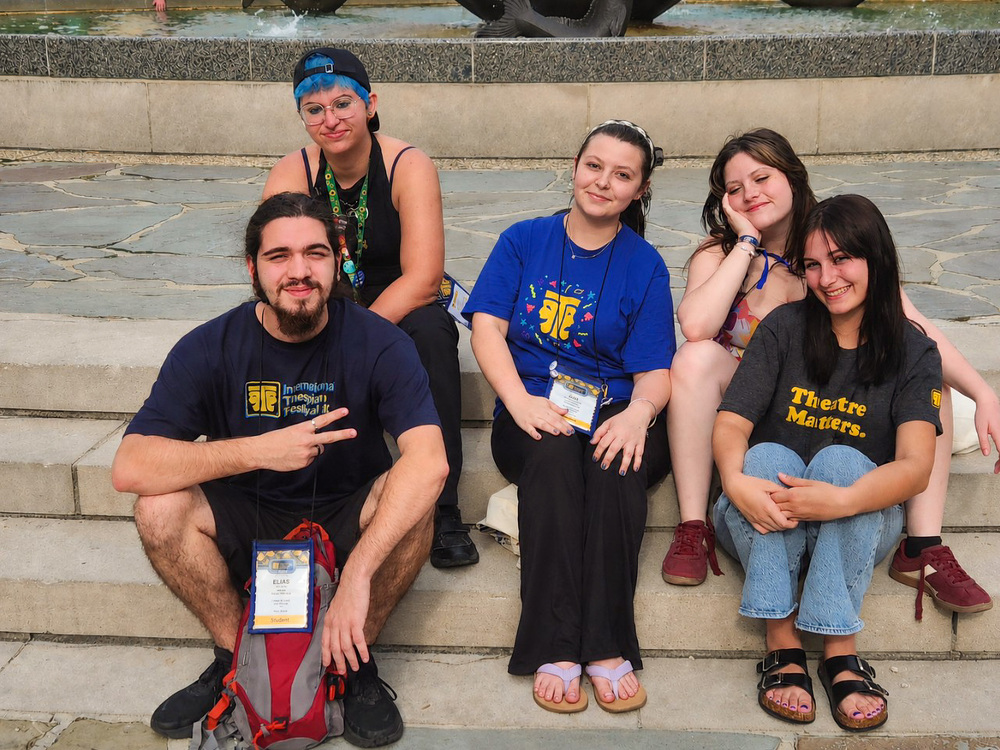 A group of students smiling on a sidewalk