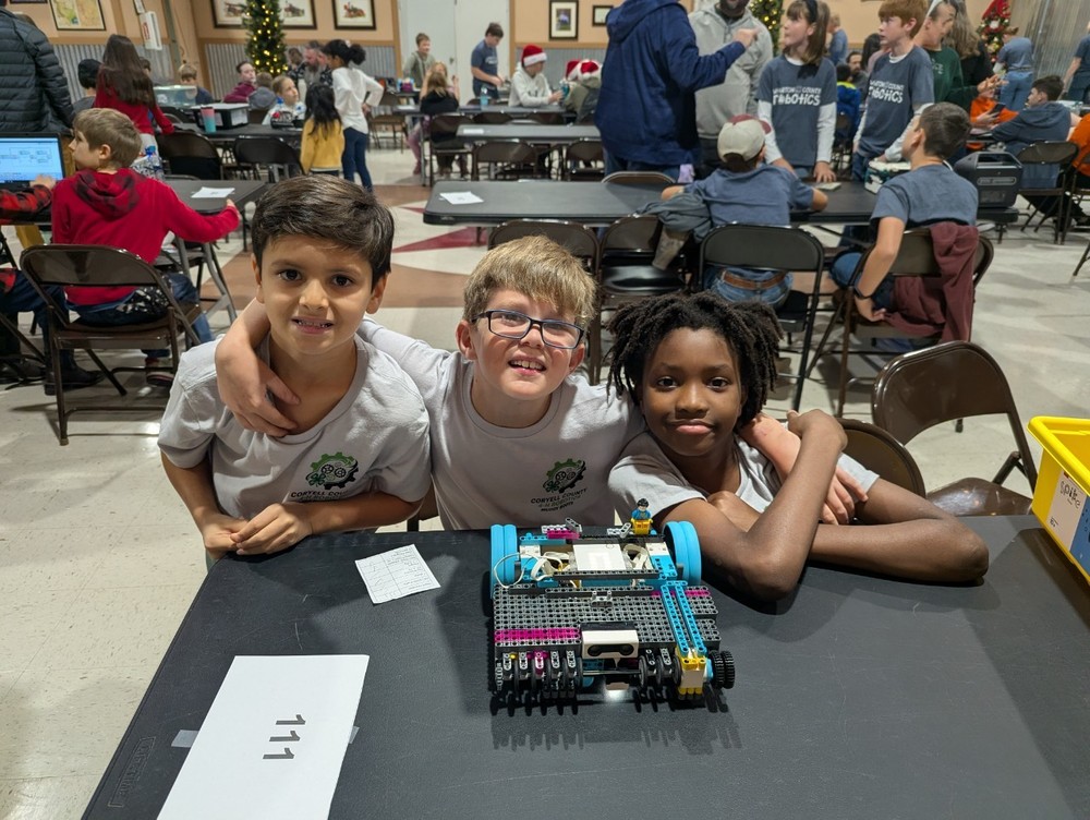 Three students with their robot.
