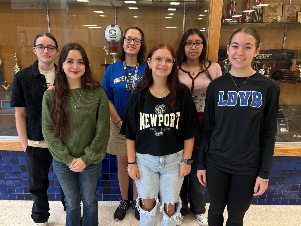 A group of students in front of a trophy case