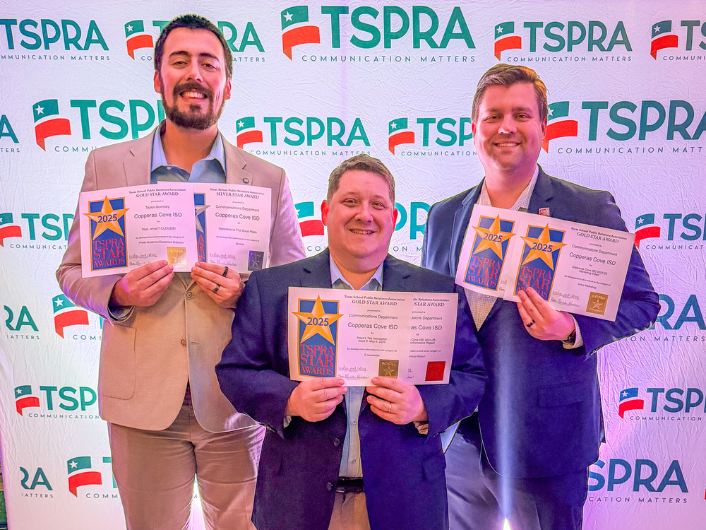 Three men holding certificates and smiling in front of a backdrop