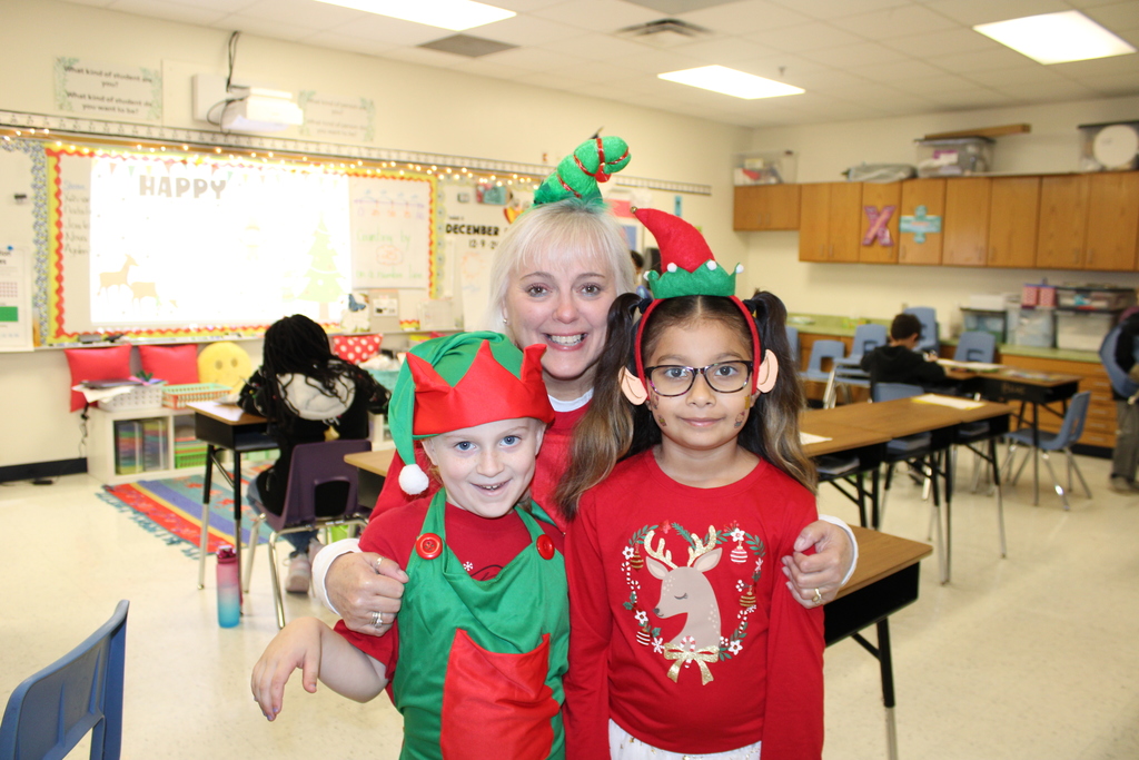 Teacher and two children dressed as elves. 
