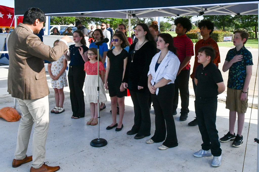 A choir performing under a tent
