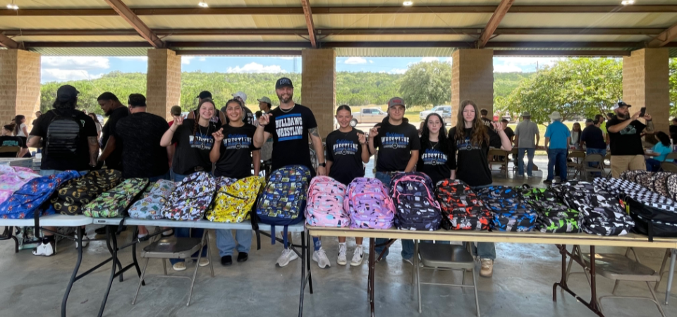 wrestling handing out backpacks