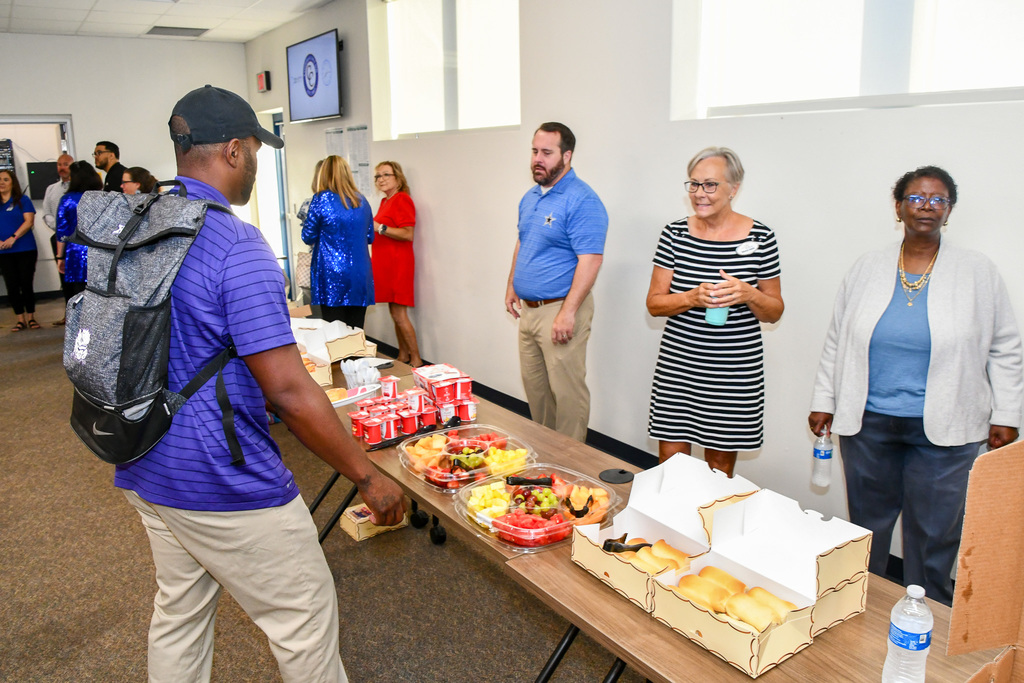 A man walking up to a table serving breakfast