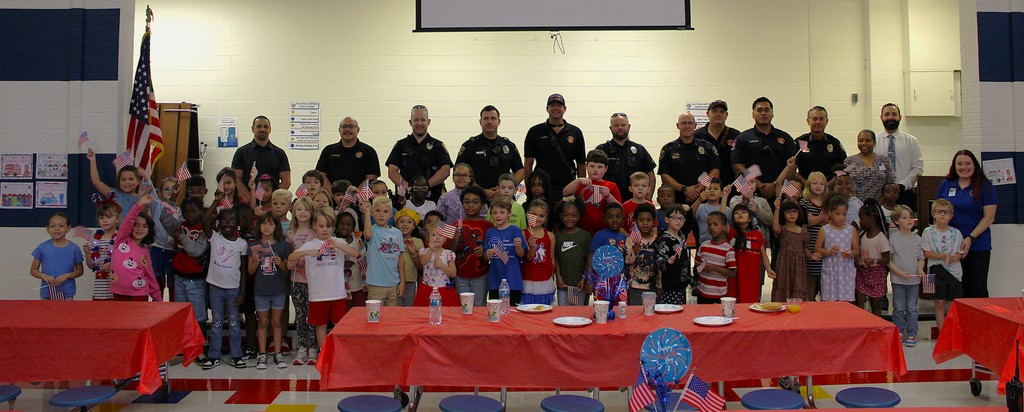 First Grade students and First responders line up on stage