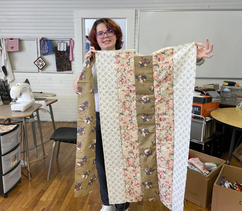 Student showing sewing project