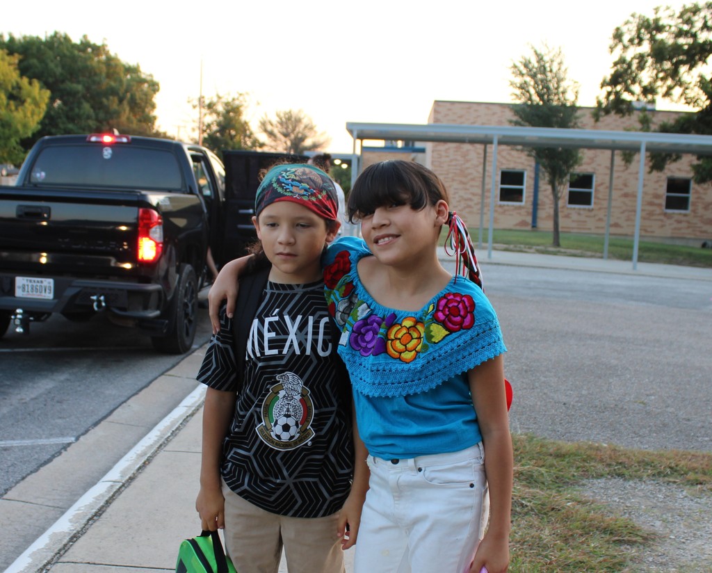 two students smile outside school