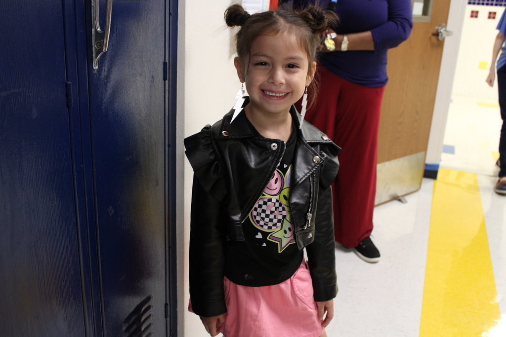 student in leather jacket smiles in hall