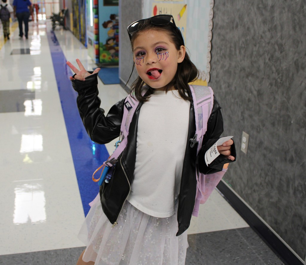 Student in rockstar makeup poses in hallway
