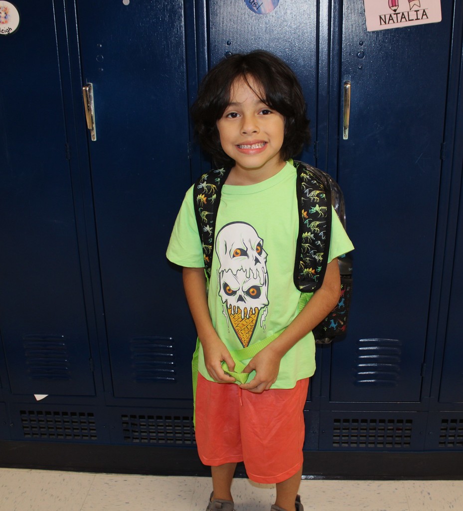 student with neon shirt smiles by locker